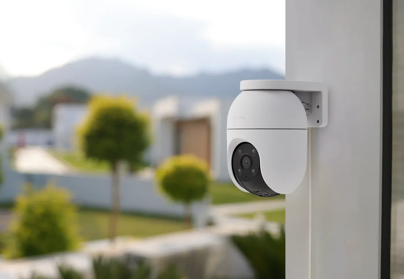 La C8c 2K fixée sur un angle de mur blanc, orientée vers une allée de jardin