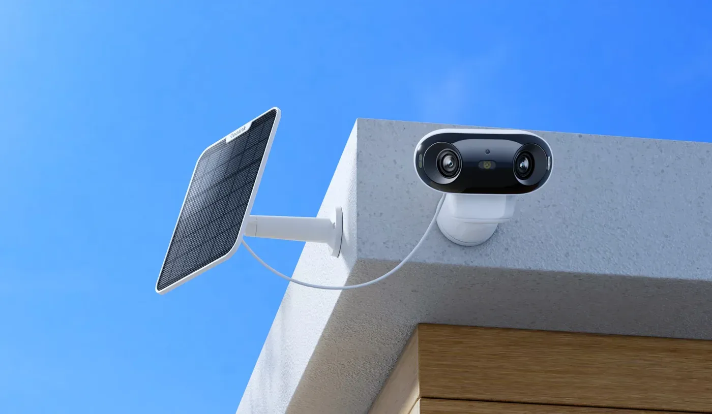 La Reolink Argus 4 Pro fixée à l'angle d'un toit blanc, son panneau solaire orienté vers le ciel